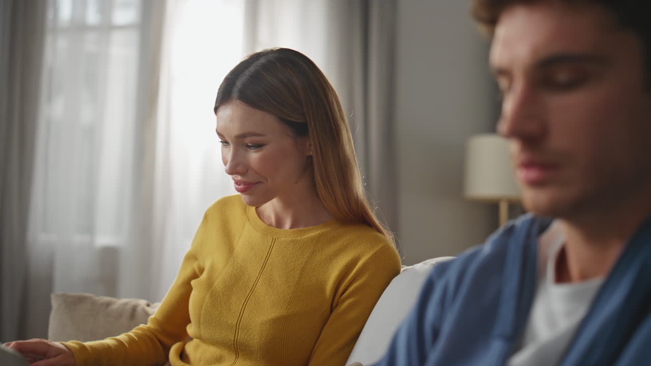 Closeup man fingers working laptop at apartment. Smiling woman looking husband