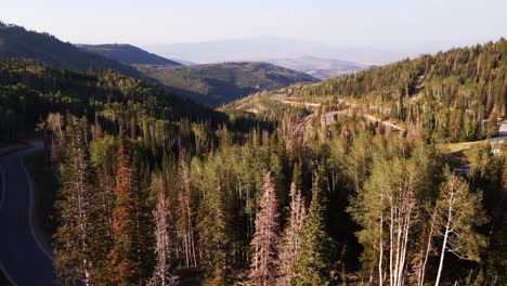 reverse aerial dolly over winding road through guardsman pass, utah