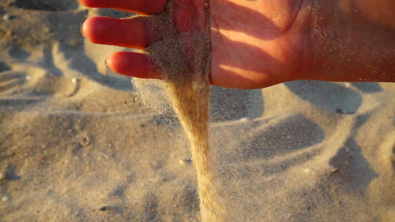 La donna sulla spiaggia raccoglie la sabbia. Slow motion. Riprese in spiaggia
