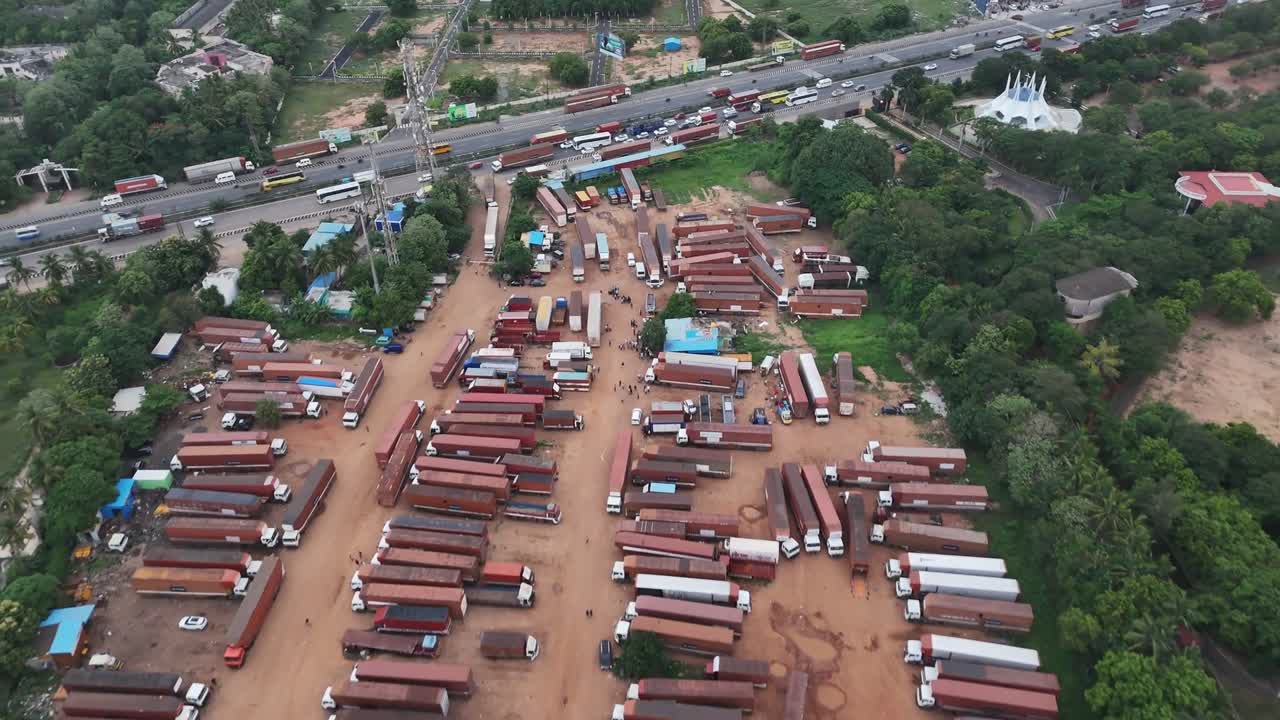 Aerial view of powerfully illustrates the daily challenges of urban mobility and logistics in a bustling metropolis. The gridlocked traffic, dominated by commercial vehicles