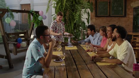 Friends and family gather for an outdoor birthday celebration