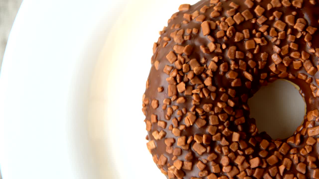 deliciosa rosquilla dulce con helado de chocolate girando en un plato. mesa de madera rústica. en bucle