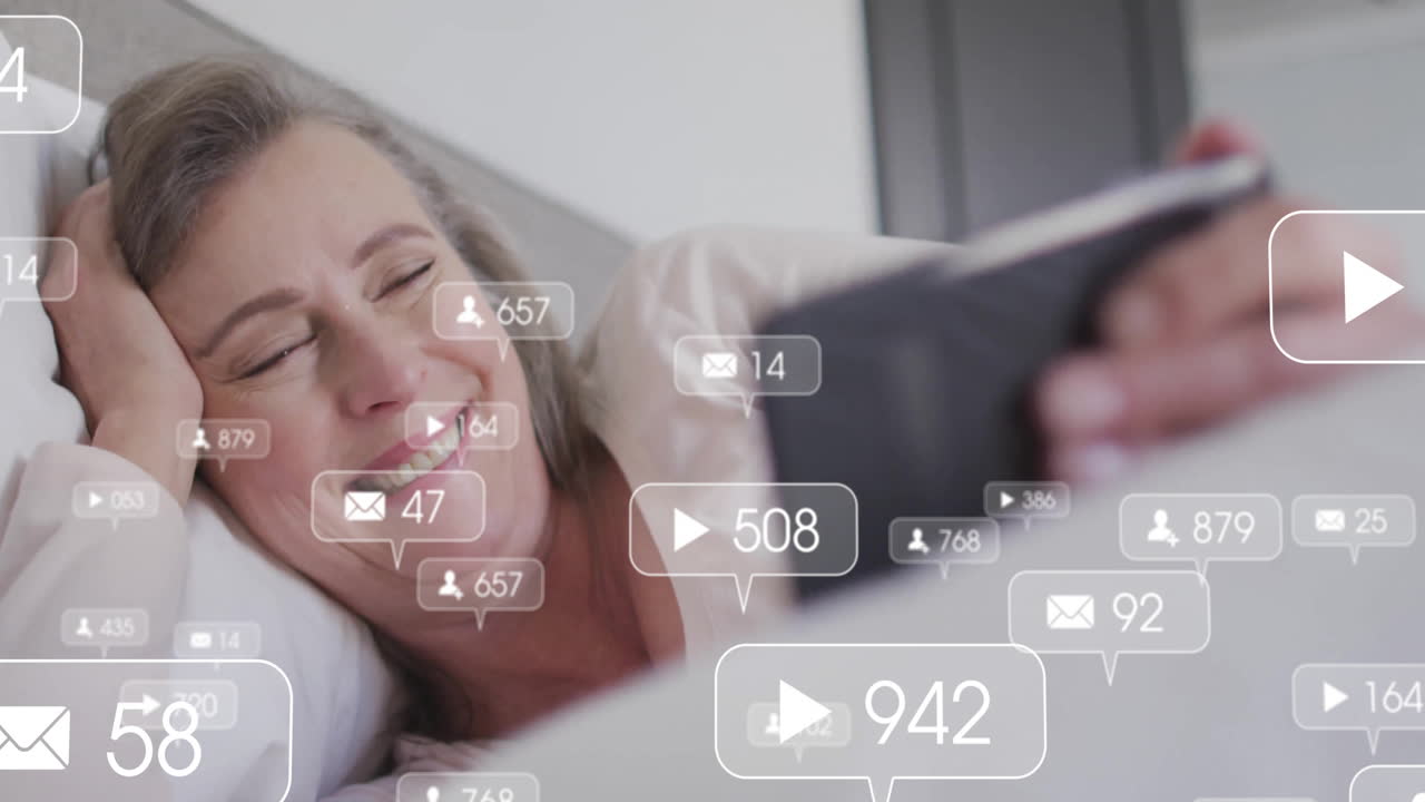 Adult woman lying in bed using tablet, showing floating social media icons and technology metrics
