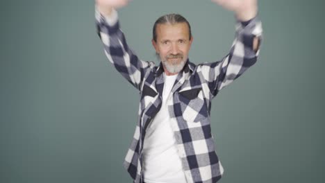 man making heart sign at camera.