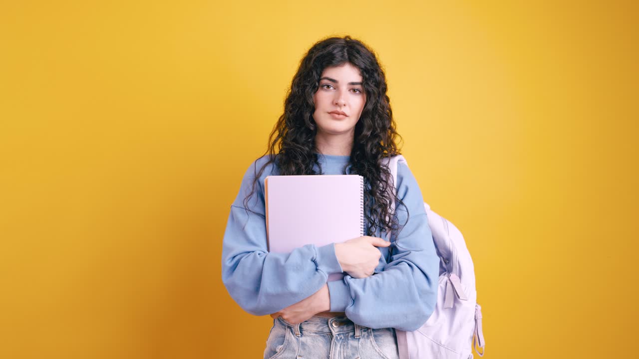 Young woman with thumbs down and school supplies