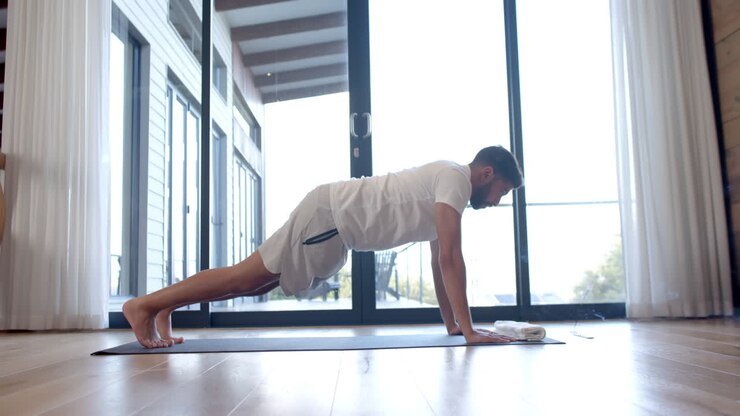 Uomo birazziale che fa yoga e stretching a casa, al rallentatore
