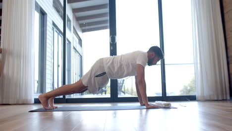 Hombre-Birracial-Haciendo-Yoga-Y-Estirándose-En-Casa,-Cámara-Lenta