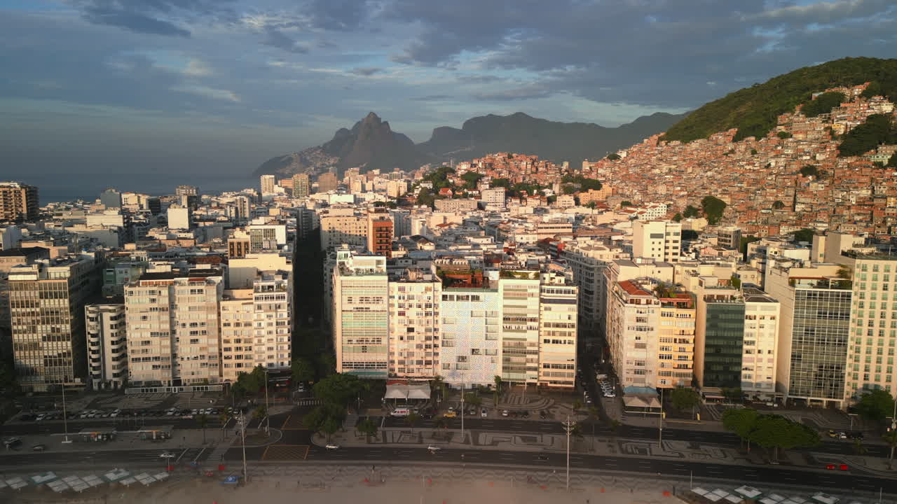 Praia de Copacabana, edifícios da cidade e orla marítima durante uma manhã ensolarada. Ascensão aérea frontal passando pela névoa em direção à cidade em 4K ProRes 422.
