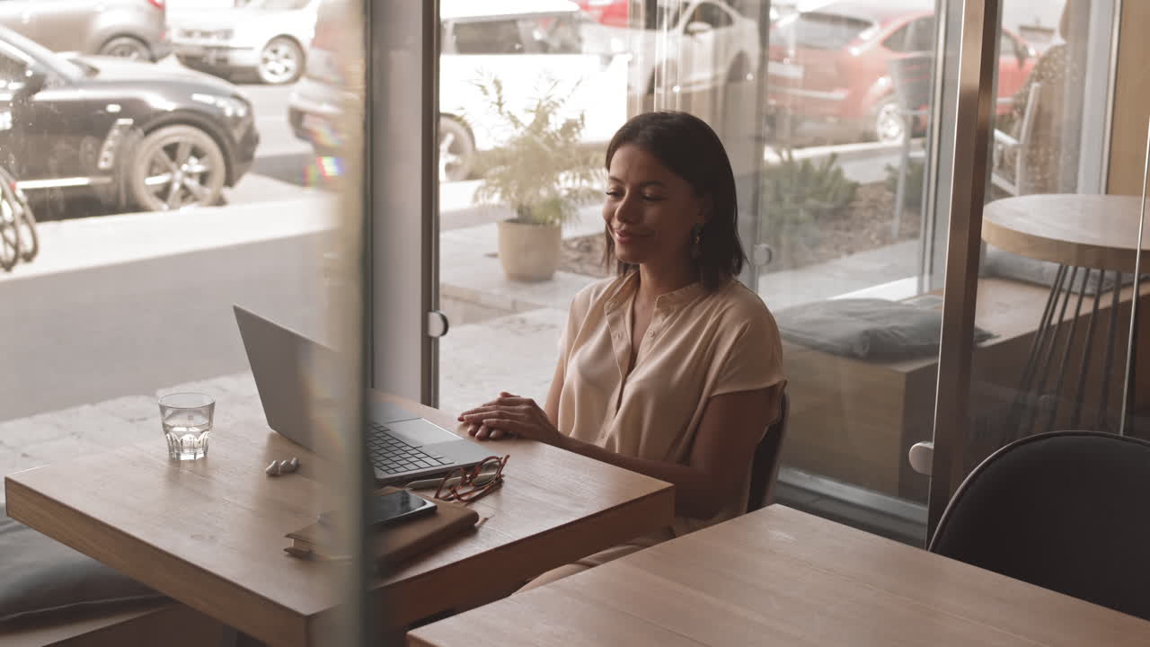 Jovem fazendo videochamada em um café