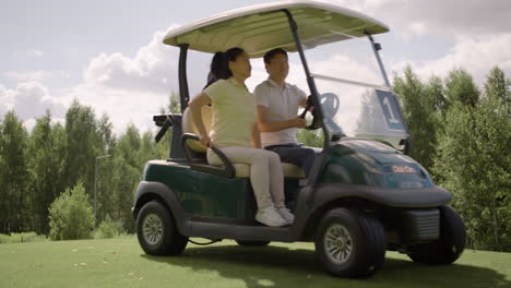 Feliz-Pareja-Asiática-Llegando-Al-Campo-De-Golf-En-Carrito-De-Golf