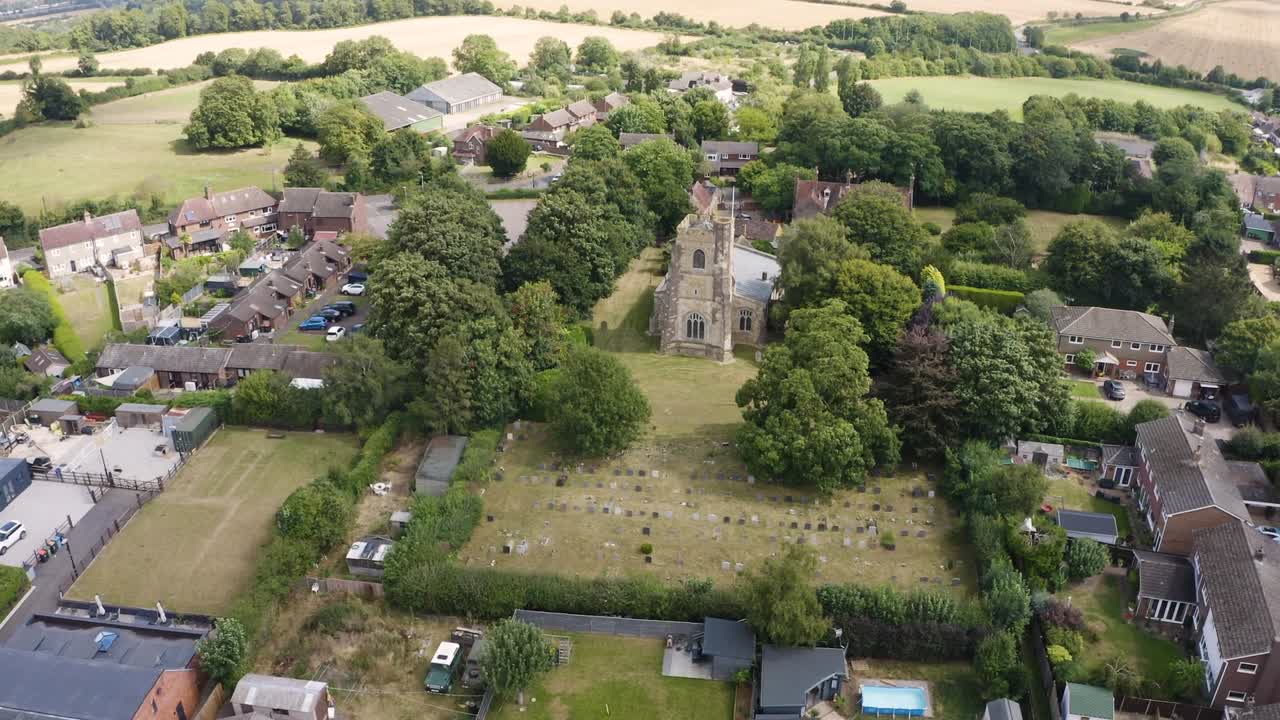 Aerial drone captures scenic footage of historic buildings nestled amidst lush forest in England, UK