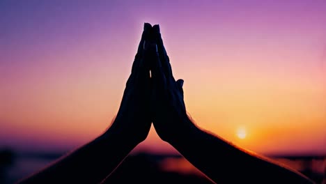 couple joins hands against a stunning sunset backdrop, symbolizing love and togetherness in a serene outdoor setting