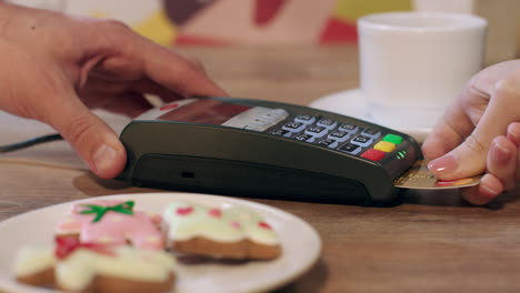 pago de terminal pos para el pedido en la cafetería. mujer pagando con tarjeta de crédito con chip