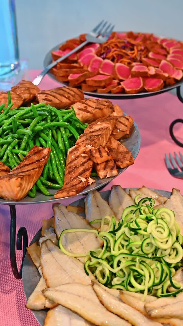 インゲンと魚が添えられたマグロのたたきと焼き鮭。マグロのスライスと焼き鮭の切り身、温野菜の付け合わせを含むシーフードの盛り合わせ。