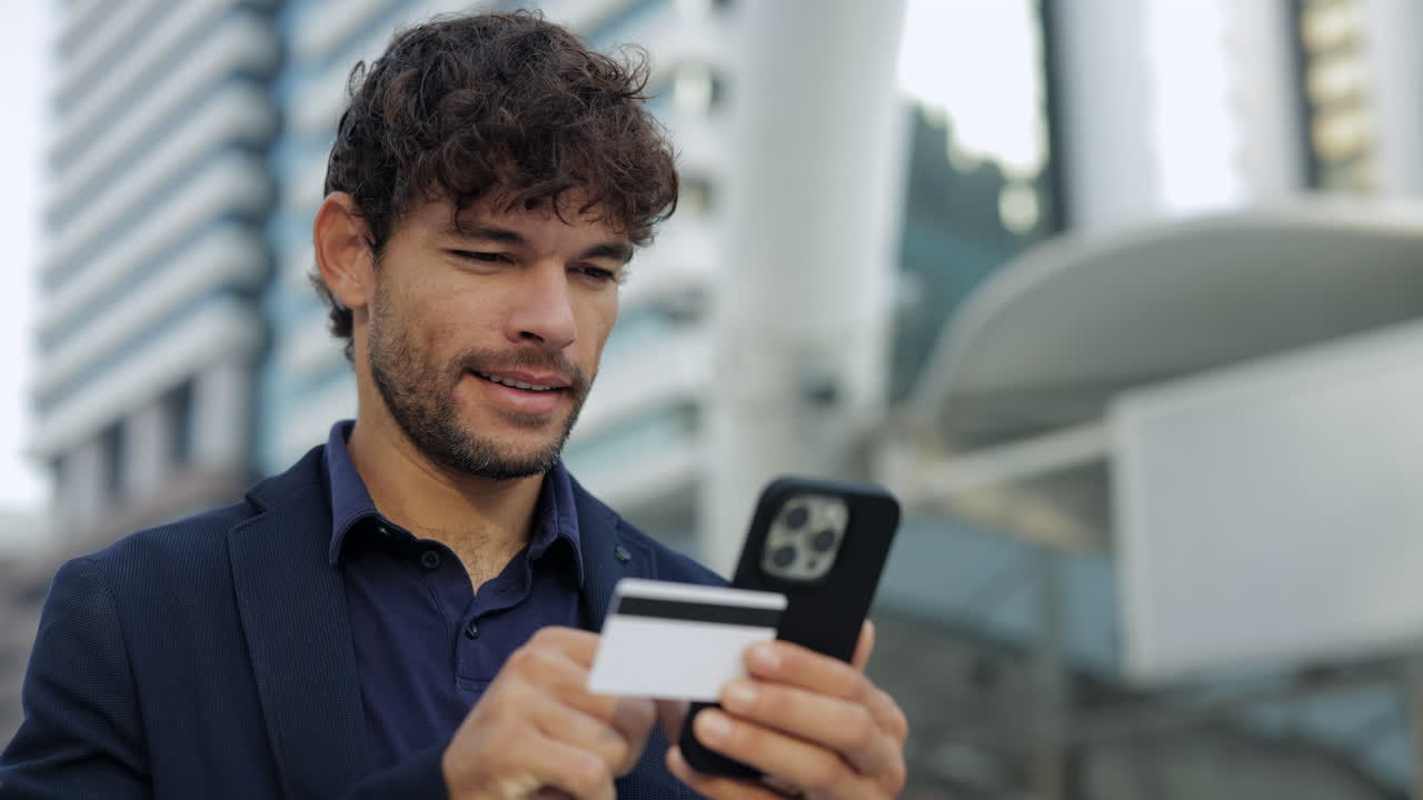 Giovane uomo che effettua un pagamento online con carta di credito su smartphone