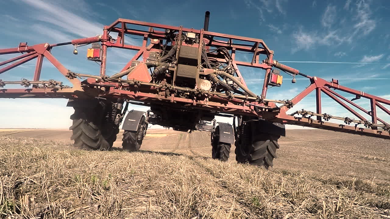 밝고 화창한 날에 제초제를 살포하는 농지에서 일하는 농업 농장 트랙터