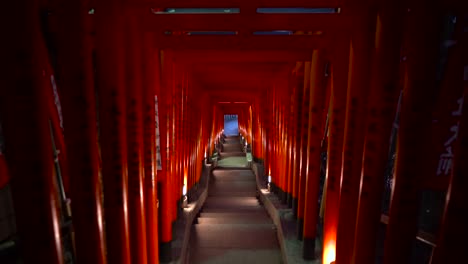 POV-Stil,-Der-Nachts-Enge-Stufen-Hinuntergeht,-Die-Von-Wunderschönen-Japanischen-Roten-Torii-Toren-Eingerahmt-Werden