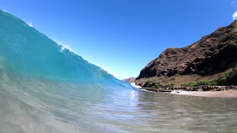 tiro en cámara lenta extrema de estar dentro del pequeño barril de una ola de ruptura de orilla en una playa hawaiana