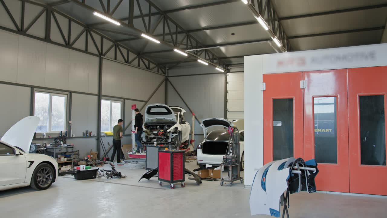 Car Repair Shop with Workers and Vehicles Under Repair