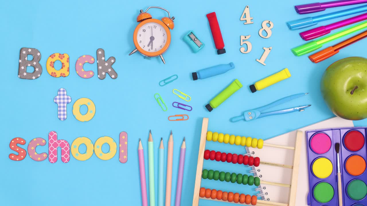 Back to school text appear next to school stationery and moving clock. Stop motion