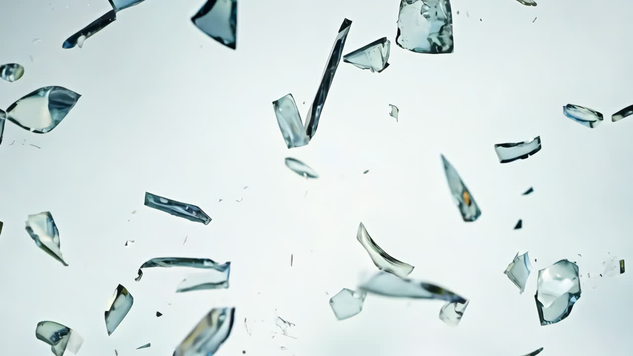 Shattered Glass Fragments Floating in Air Against a Light Background. Glass shards are suspended in mid-air, reflecting light and creating an abstract visual dynamic.