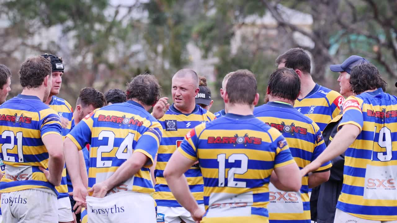 Tým v pruhovaných uniformách diskutující strategii venku