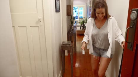 a beautiful woman opening the door and expressing excitement getting inside - wide shot