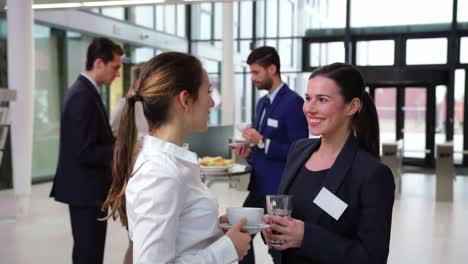 Smiling-businesspeople-interacting-with-each-other-during-break