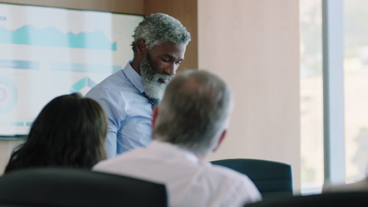 business people celebrating congratualting african american businessman presenting successful solution to shareholders clapping hands applause in office boardroom meeting