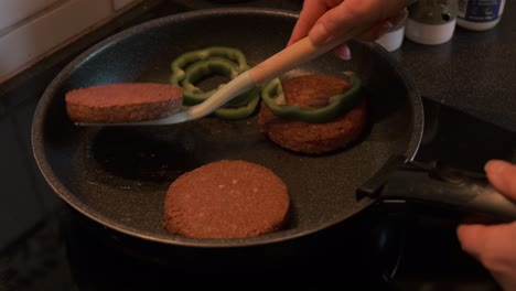 cocinar hamburguesas vegetarianas con pimiento verde en una estufa en cámara lenta de 4k