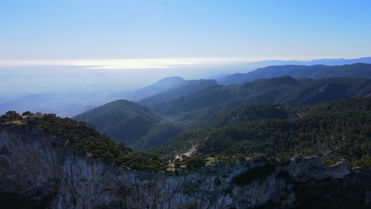 Discover the stunning views of Mallorca's Tramontana mountain range, overlooking the sparkling Mediterranean Sea towards Cap Formentor and Alaro Castle. Experience nature at its finest.