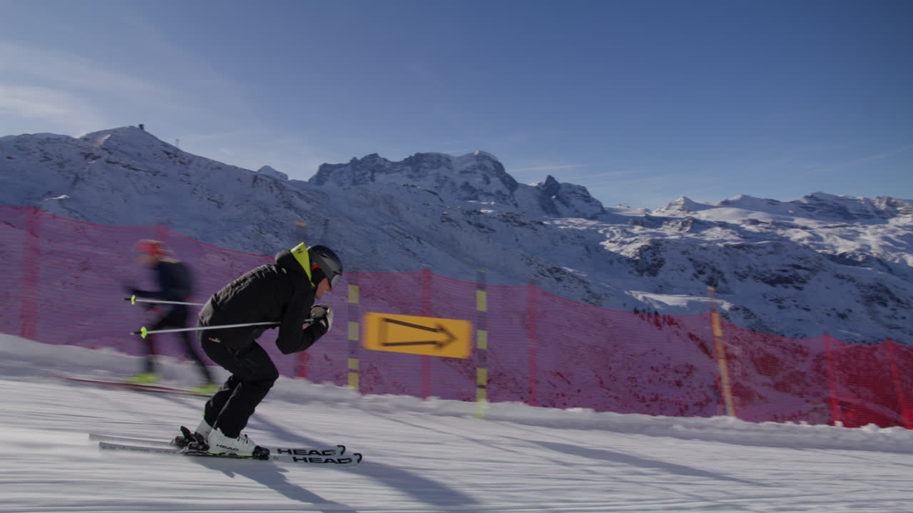 Skiing in Zermatt under the Matterhorn during a blue bird day and perfect slopes. High performance carving on skis.