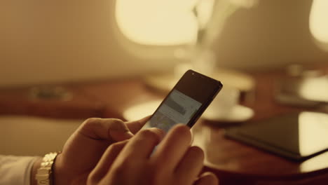 Businessman-analyzing-smartphone-financial-graphs.-Closeup-hands-holding-phone