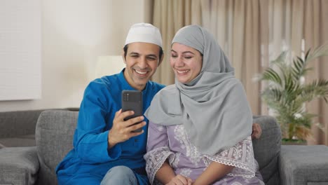 happy muslim couple talking their child on video call