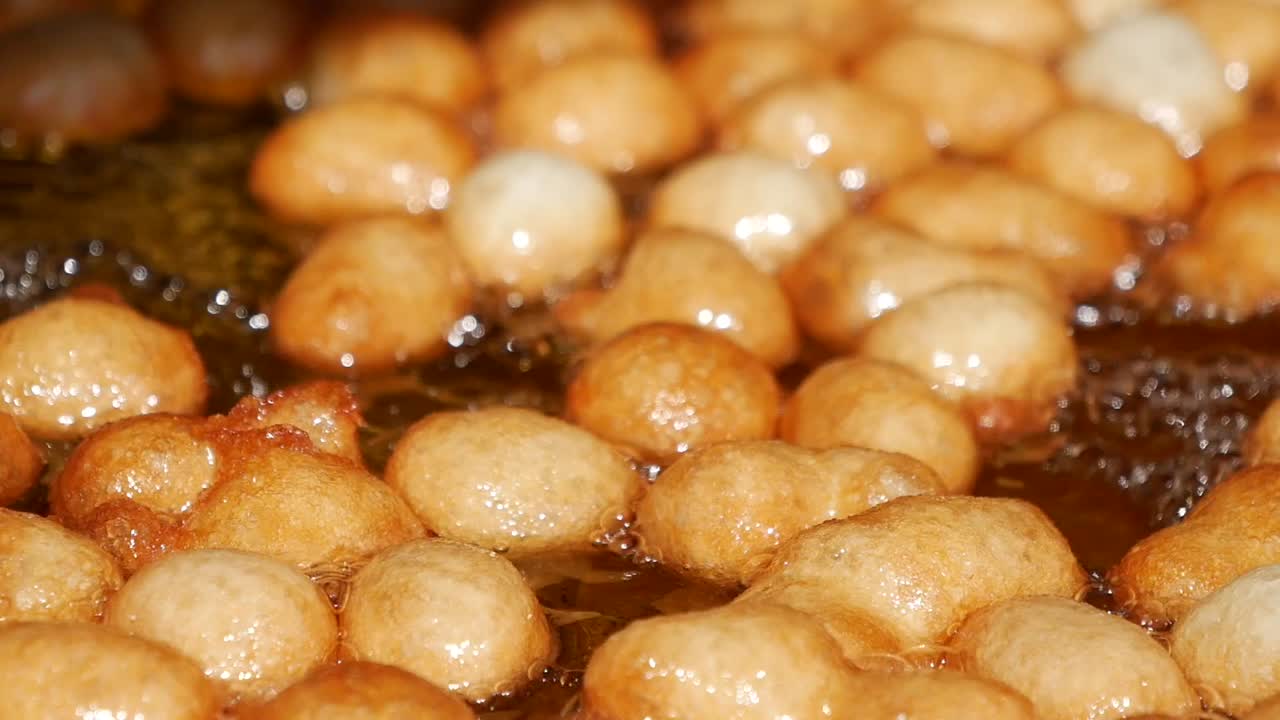 Deep-fried dough balls cooking in hot oil