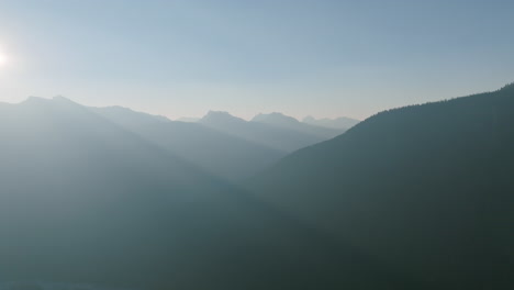 Aerial-footage-of-the-sun-shining-through-the-Cascade-Mountains-in-the-early-morning-light