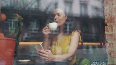 woman enjoying coffee and using phone in a cafe