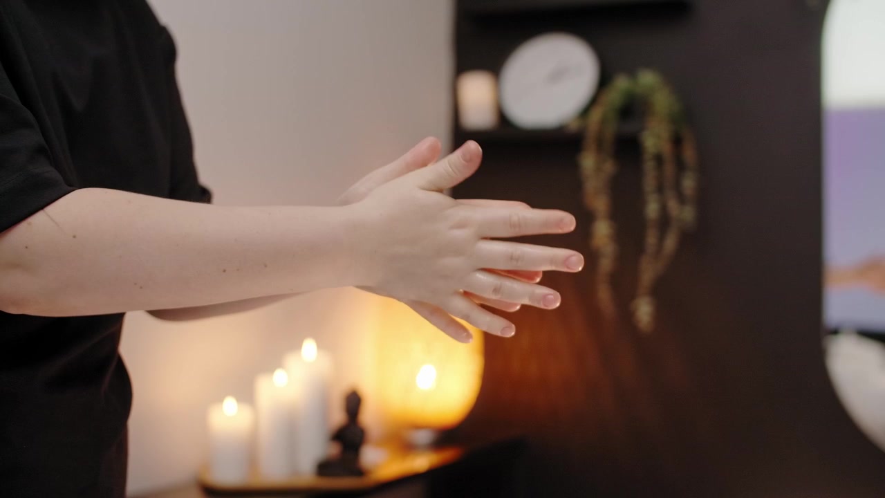 Massør varmer massageolie i hænderne