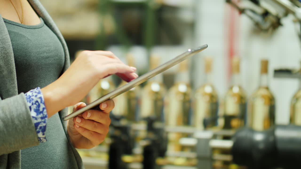 Woman Using Tablet in Wine Bottling Plant
