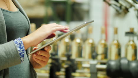 woman using tablet in wine bottling plant