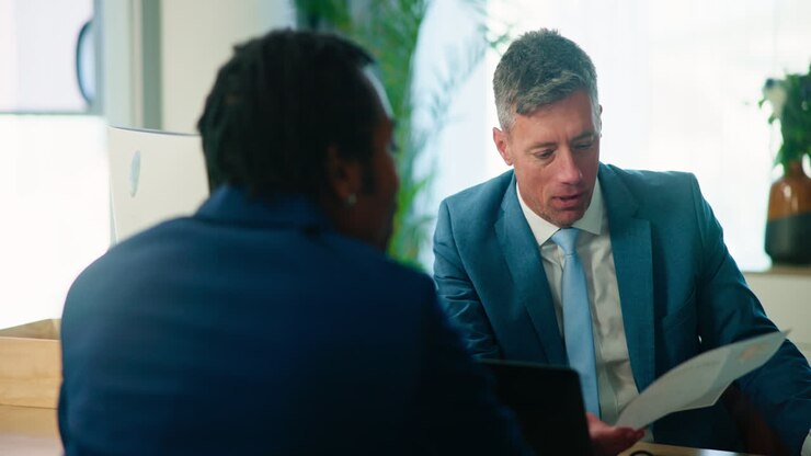 Two men in suits have a business meeting in an office