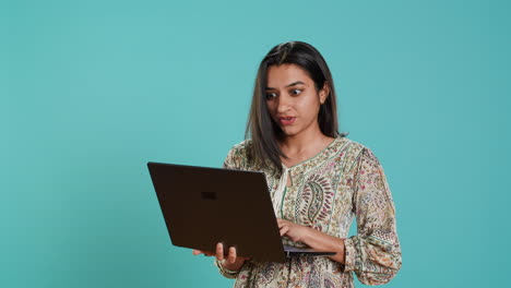mujer componiendo correo electrónico, escribiendo en una computadora portátil, frustrada por un teclado defectuoso