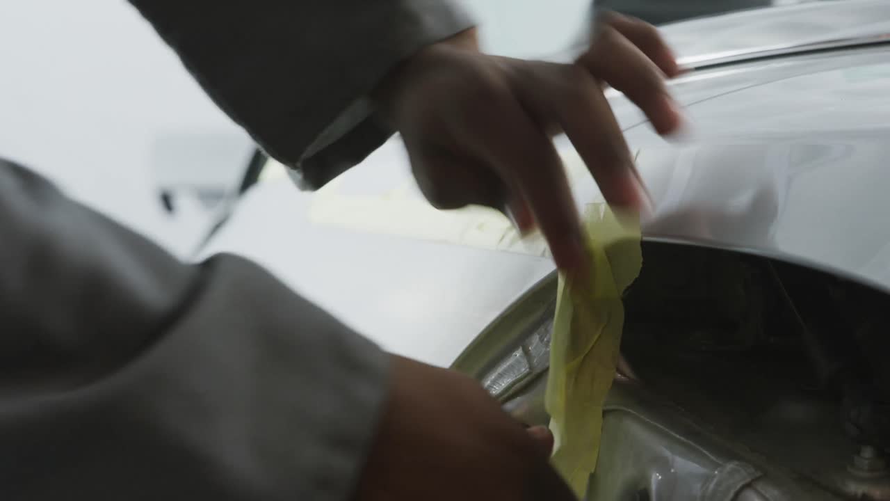 mecánico de automóviles afroamericano grabando un cuerpo de un automóvil