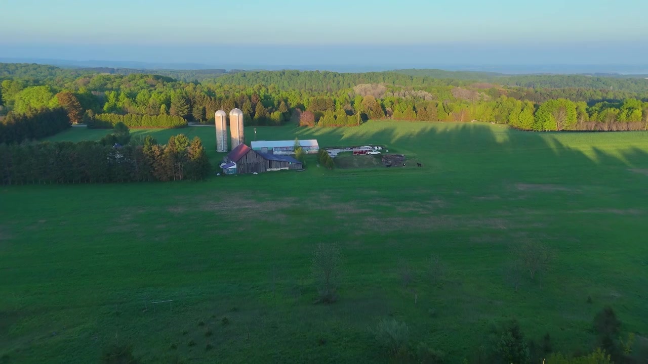 Luftfoto, der afslører en gård med en rød lade og siloer ved solnedgang i Leelanau County, Michigan