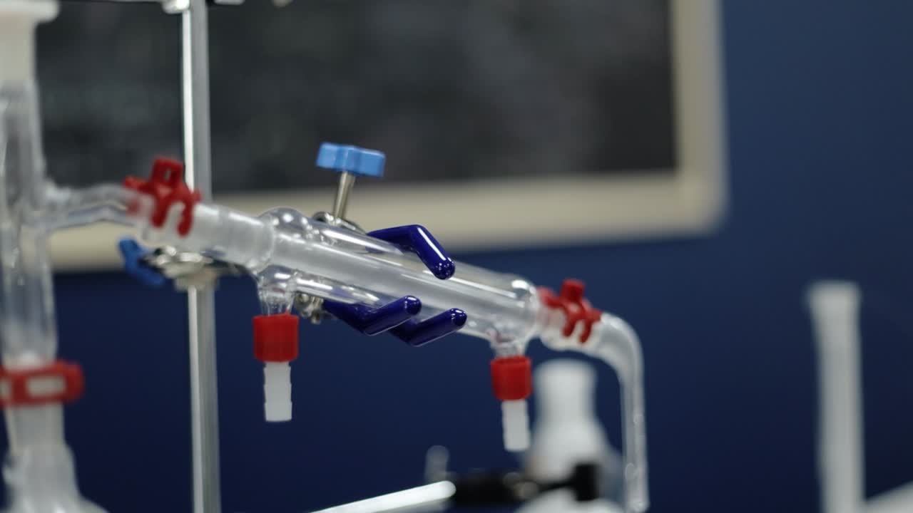 в замедленном отображении лабораторные стеклянные трубки показывают тонкие химические взаимодействия, подчеркивая методическую точность и сложность, присущие научным исследованиям и экспериментам