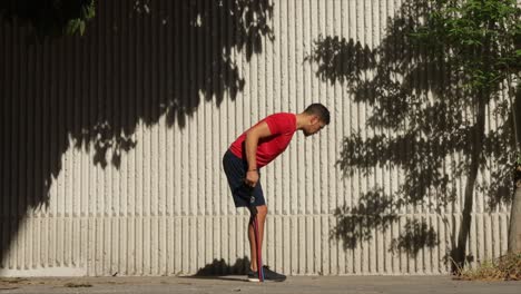 Mexican-man-exercising-with-rubber-bands-outdoors-on-a-sunny-day