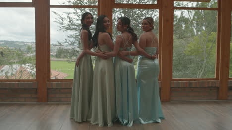 charming clip of four bridesmaids standing with their backs to each other, turning their heads at the same time to smile at the camera.
