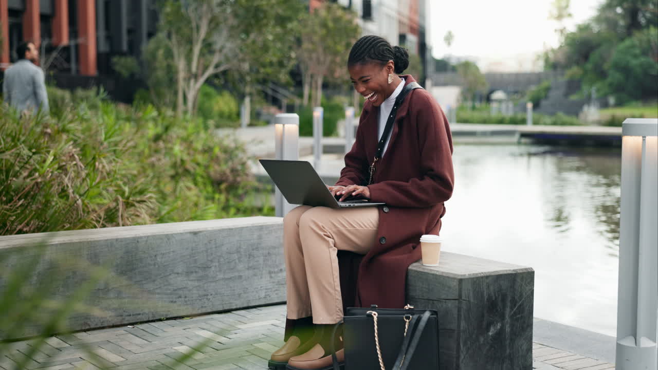 Woman working on a laptop in a city park