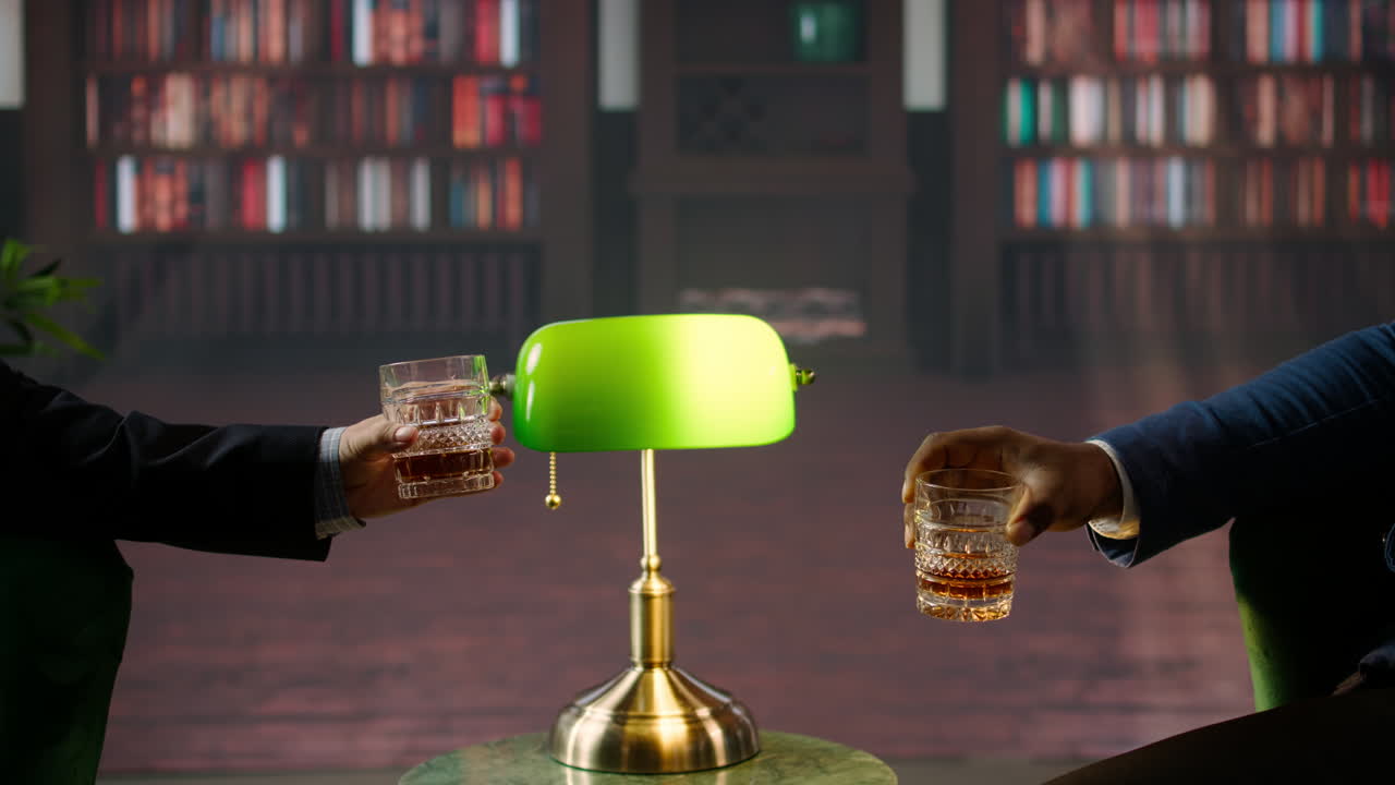 은 돈의 상속자들은 위스키 컵을 고 그들의 파트너십을 위해 건배합니다.