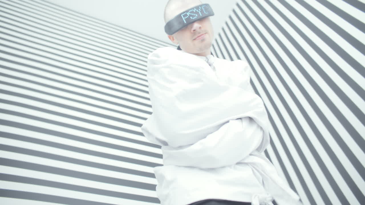 Man in Restraints with VR Glasses in a Striped Room